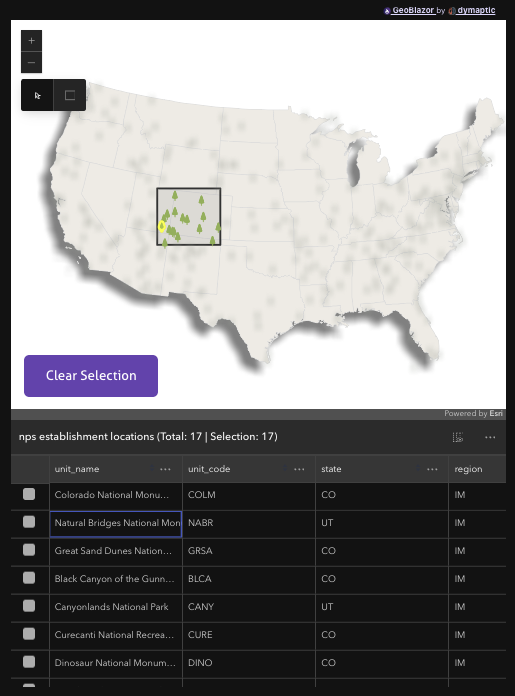 The Highlight Features by Geometry sample from GeoBlazor Pro, showing a map of the contiguous United States with a drawn selection rectangle over Colorado and Utah, the matching national park locations highlighted in green while the rest of the map is dimmed, a Clear Selection button in the lower left, and a feature table below listing the 17 selected NPS establishment locations.